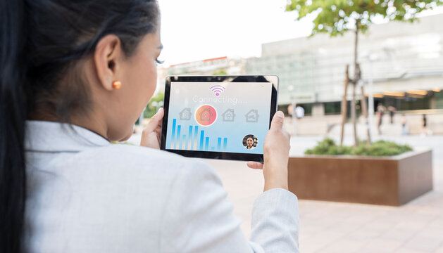 Businesswoman holding digital tablet with house and bar graph icon