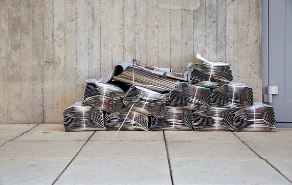 Newspaper stacks lying in front of apartment building