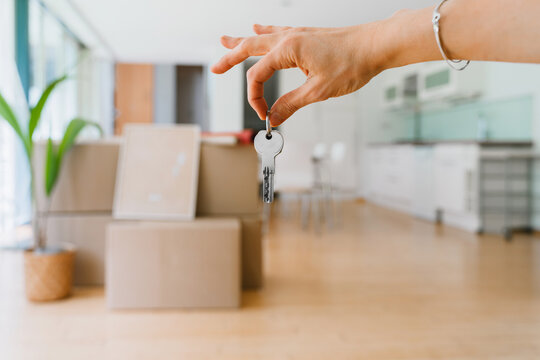 A woman holds a key to her new apartment indoors on moving day