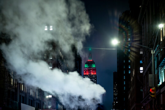 USA, New York, New York City, Smoke floating against illuminated Empire State Building at night