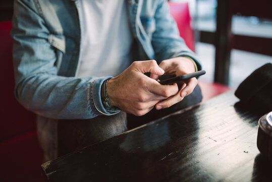 Young man text messaging, partial view