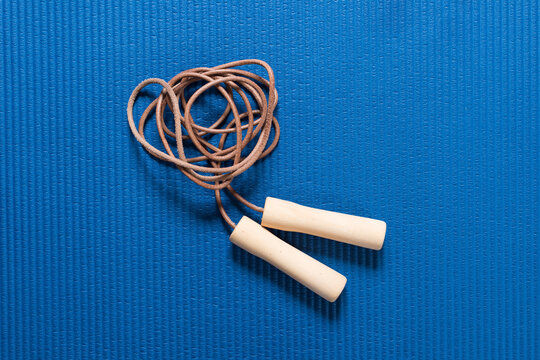 Skipping rope on blue workout mat