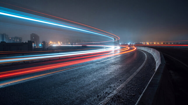 Dramatic long exposure photograph of a curved highway at night with dynamic blue, red, and white light trails.