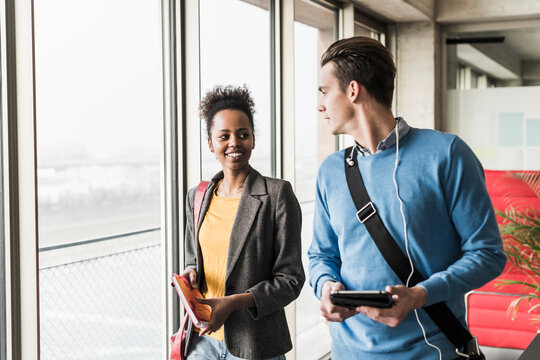 Young business people walking together in office