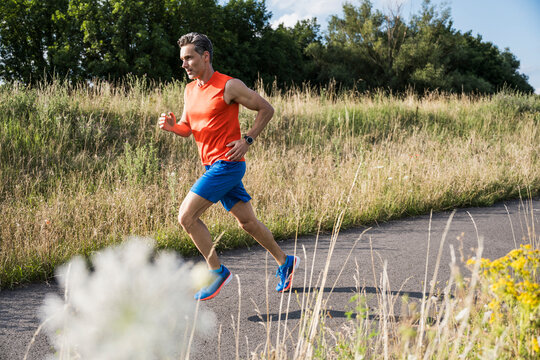 Runner jogging on a sunny outdoor path for fitness