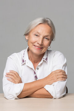 Portrait of senior woman with grey hair sitting at table
