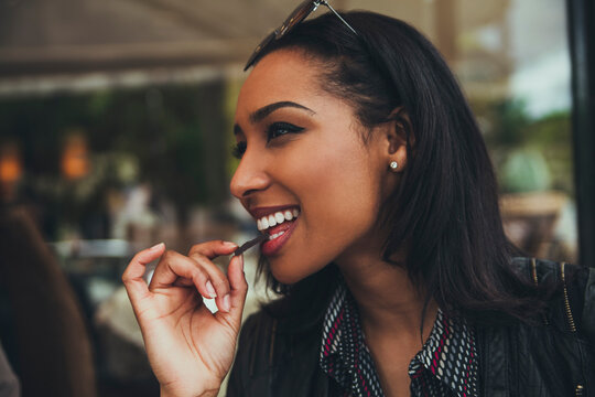 Portrait of smiling young woman eating chocolate in a cafe
