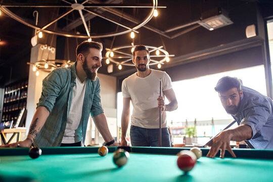 Friends playing billiards together