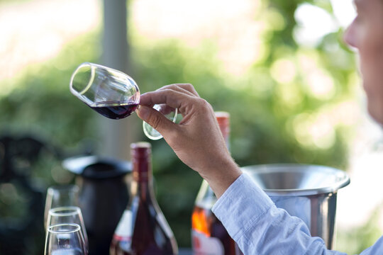 Man holding and judging glass of red wine