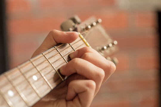 Close-up of man's hand playing guitar