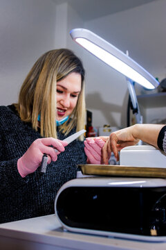 Manicurist performing nail care services in a beauty salon