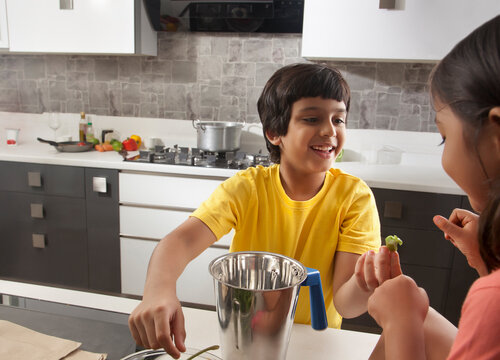 Two children having fun together in kitchen