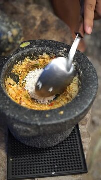 Cooking Thai food video showing close-up process of preparing traditional Asian bamboo shoot soup. The footage demonstrates boiling bamboo shoots, straining green yanang leaf juice, pounding herbs in 