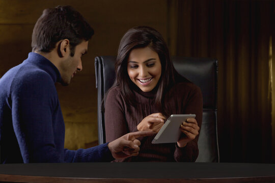 Businessman and businesswoman sitting in the office and using digital tablet