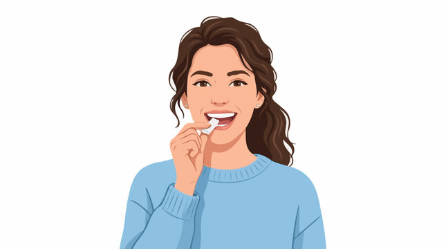 A young woman with brown hair and a blue sweater puts a small white item in her mouth, smiling confidently