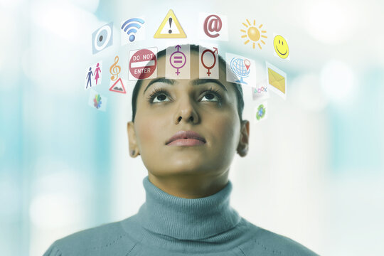 Woman surrounded by symbols and computer icons 