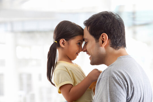 Father and daughter rubbing noses together