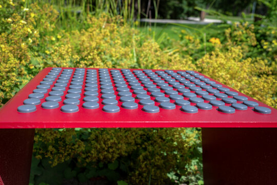 Gray Rubber Studs Pattern a Red Metal Seat in Sunny Park