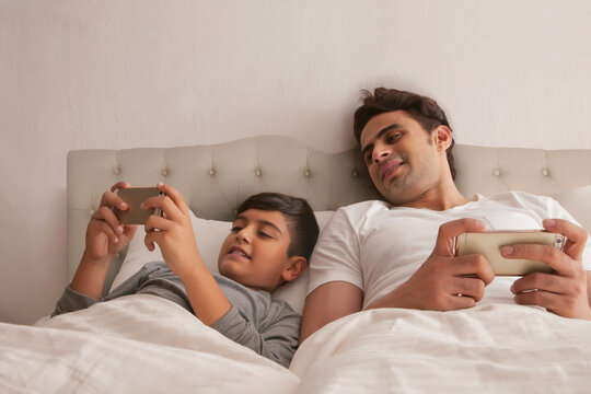Family using mobile phone in bed
