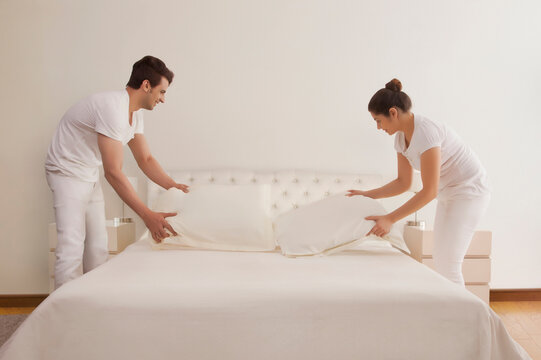 Couple making bed together