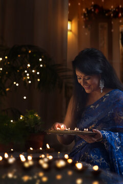 Woman arranging earthen lamps at diwali