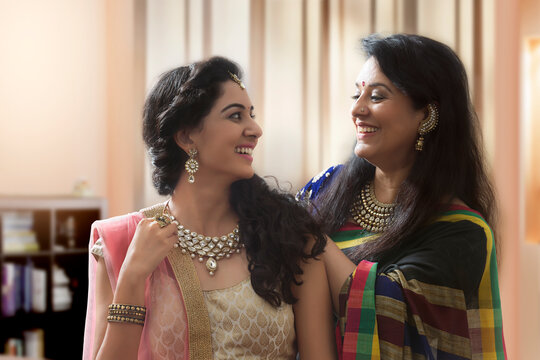 Mother putting necklace on daughter