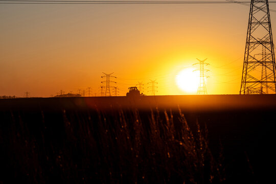 Crane Erecting Steel Transmission Tower Near Power Lines