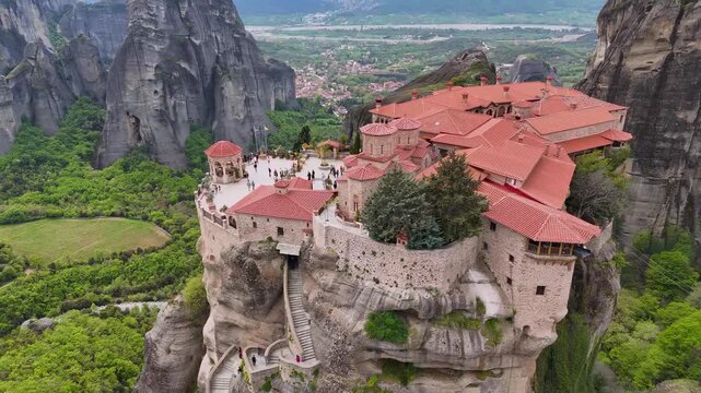 Aerial view of ancient orthodox monastery on steep rock cliff in Meteora Greece