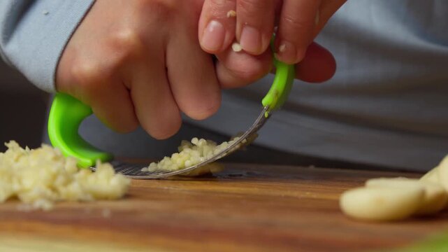 mincing garlic with garlic crusher