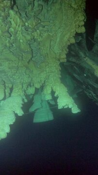 The camera glides below an uneven ceiling lined with pale suspended formations inside Cenote Zapote, Quintana Roo, Mexico.