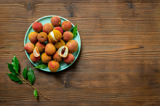Plate full of exotic lychee fruit with green leaves, top view. Healthy vegetarian meal ready to eat