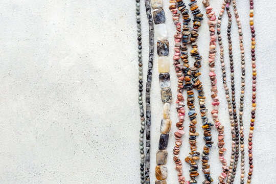 Precious and jewelry flat lay background. Lots of gemstones for necklace and bracelets, top view