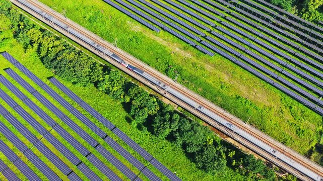 Aerial view of a high speed train beside solar panels
