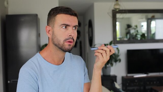 Man listening to confusing audio messages on smartphone in disbelief