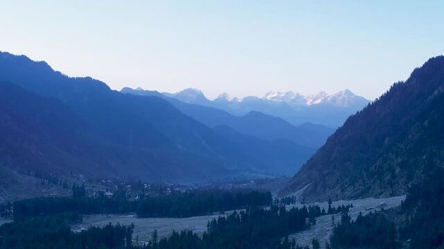 Thal Village rests below forested mountains and distant snow-covered peaks in Kumrat Valley, Upper Dir District, Khyber Pakhtunkhwa, Pakistan