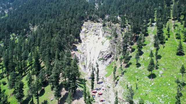 Waterfall cascades through rocky cliffs surrounded by dense conifer forest in Upper Dir District, Khyber Pakhtunkhwa, Pakistan