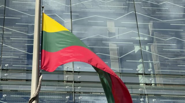 Close View of Lithuanian Flag Waving Against Glass Facade