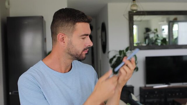 Sad man listening to worrying voice message on smartphone inside room