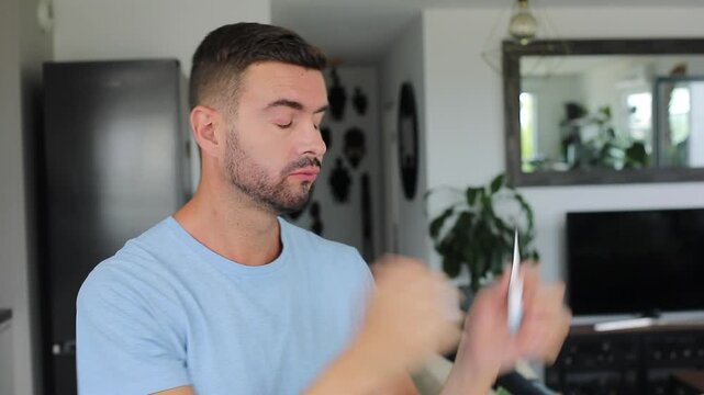 Sick man checking electronic mouth thermometer and reacting to high fever