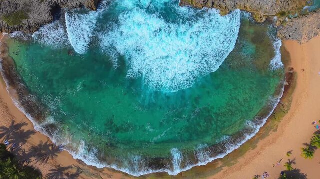 A stunning overhead drone shot reveals the horseshoe-shaped inlet and pristine golden sands of Mar Chiquita Beach, Puerto Rico.