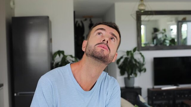Scared man looking up anxiously before getting struck on head

