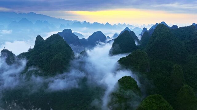 Misty karst mountain peaks and lush limestone valleys near Guilin, China, creating a compelling aerial landscape for tourism and travel concepts.