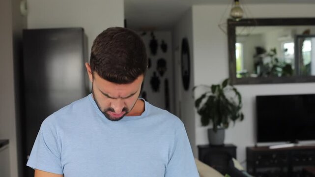 Man looking down with shocked expression at something below frame.