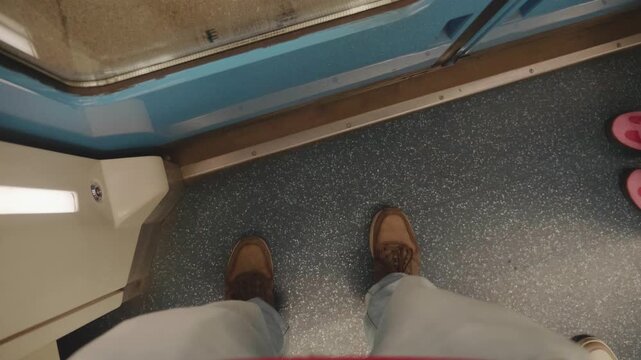 POV footage of commuter stepping off metro train carriage onto subway station platform