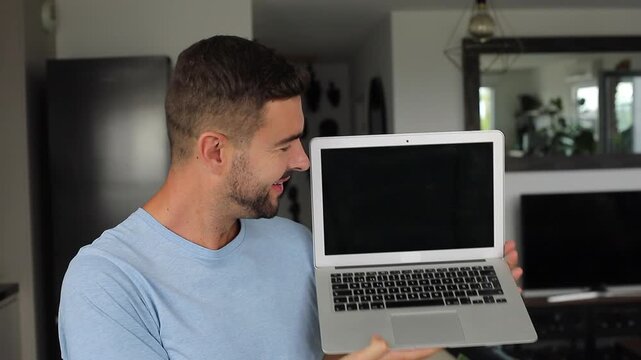 Happy man opening modern laptop computer and smiling at camera screen