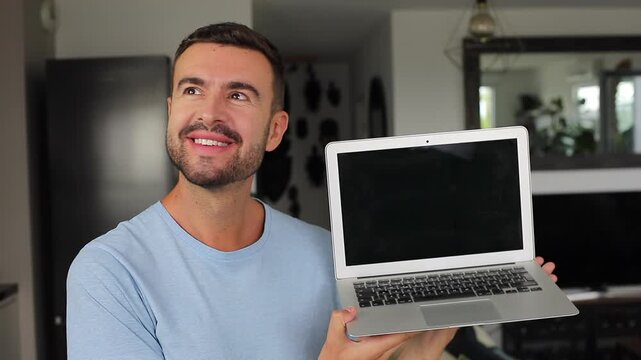 Happy man opening modern laptop computer and smiling at camera screen