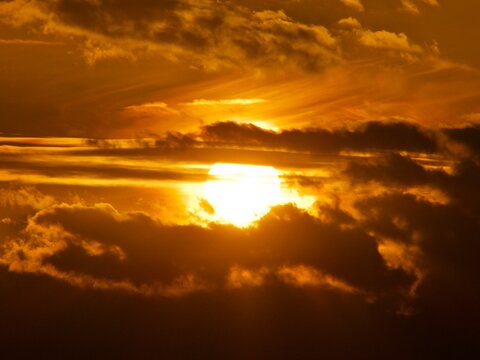 Golden sky sunset hiding behind dark clouds
