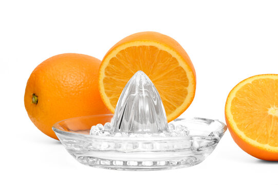 Beautiful ripe juicy oranges arranged on a glass fruit squeezer isolated on a white background