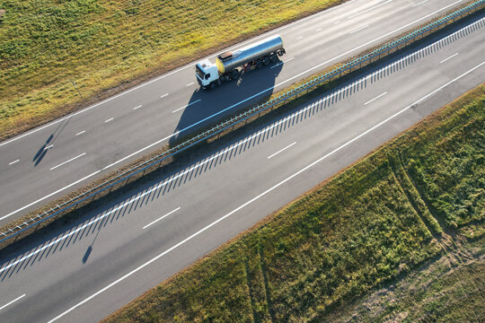 Aerial view of a tanker truck driving along a highway through rural fields in Chachevichy, Mogilev Region, Belarus.