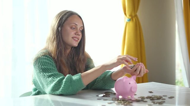 Woman saving money in piggy bank. Female hands placing coins into piggy bank. Smart saving strategy for future profits. Woman manages her savings for profit growth. Budgeting for increased profits.